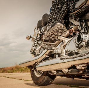 Biker girl riding on a motorcycle. Bottom view of the legs in leather boots.